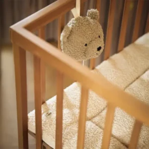 peluche musicale sur un lit bébé